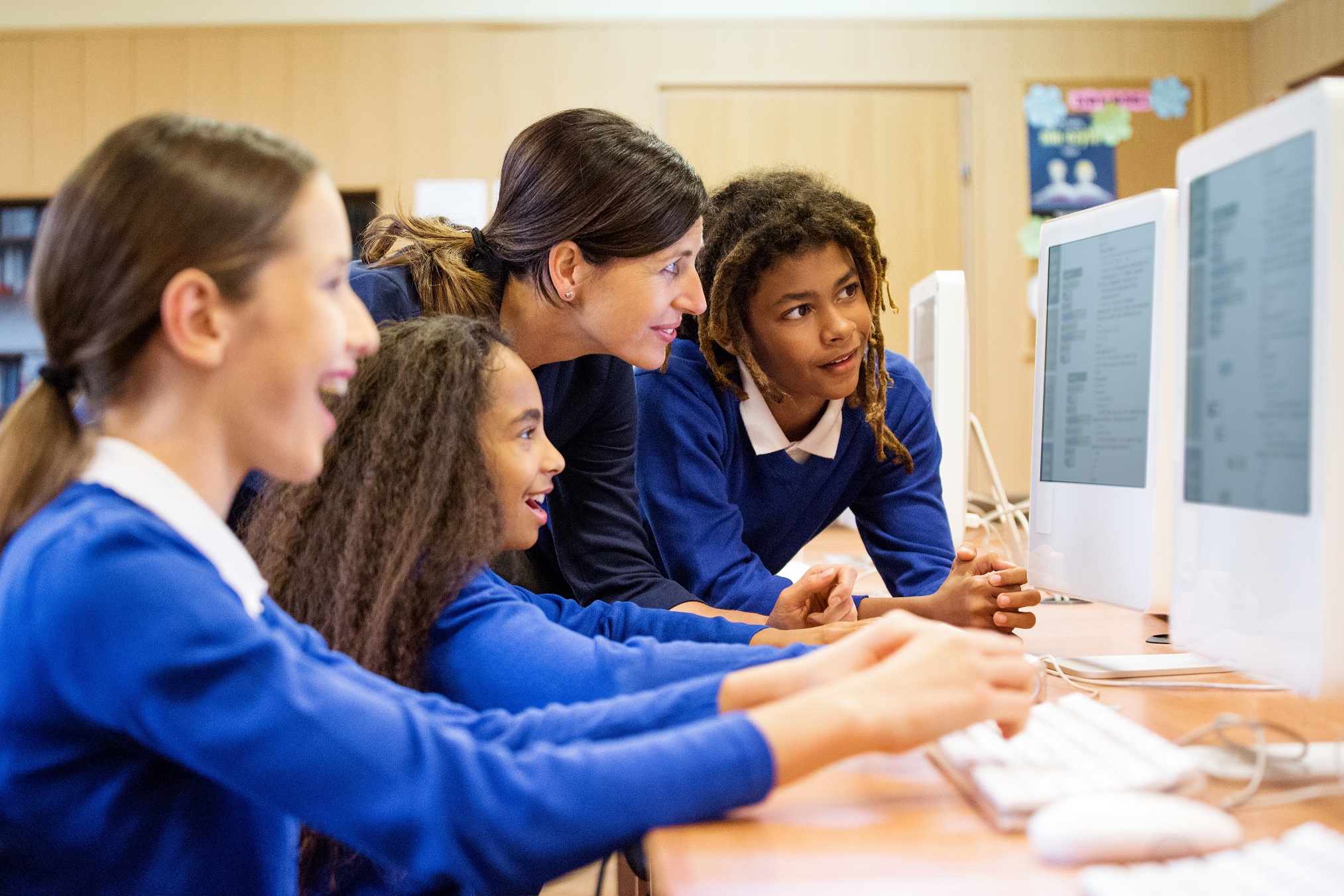 Teacher looking at computer with students