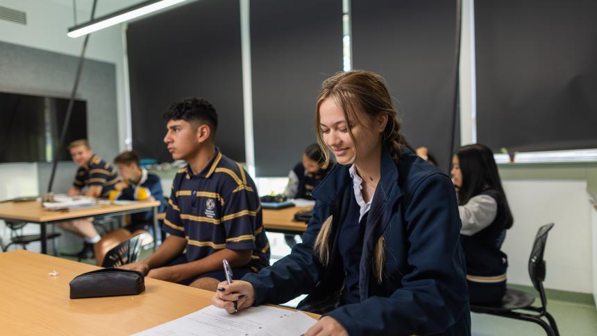 A female student writes in a notebook.