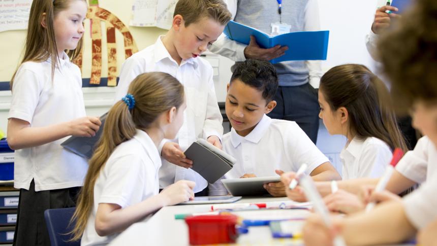 five primary students discussing work