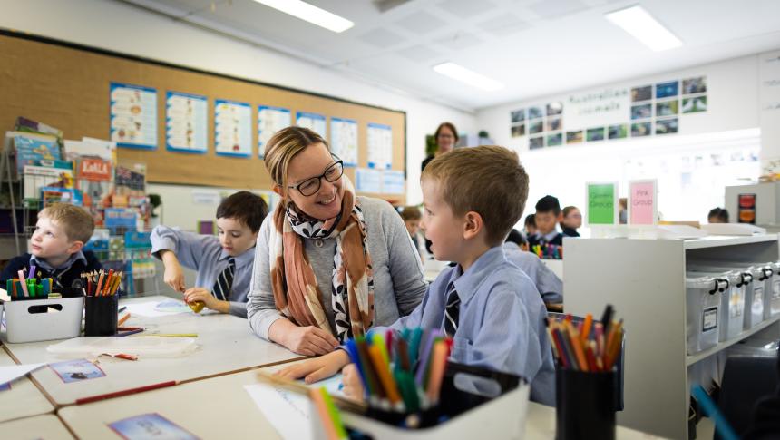 Teacher sitting next to student