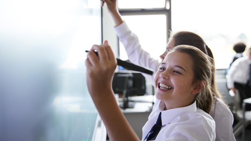 Two students writing on a whiteboard