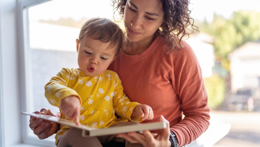 Adult and child sharing a board book