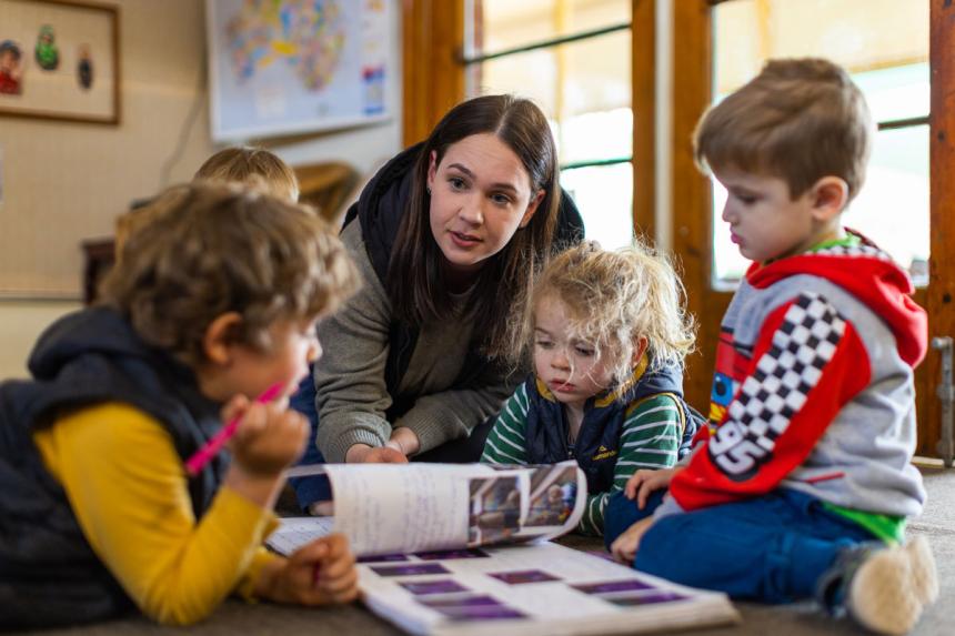 An educator with three preschool students.