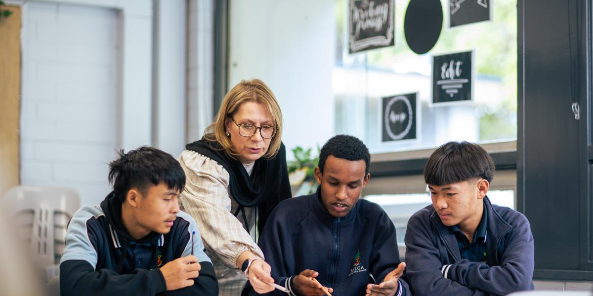 teacher in class with three boys